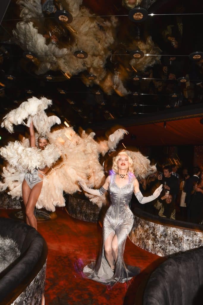 Fay Loren met groot Champagneglas act met showgirls